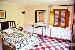 Un dormitorio con una cama y un suelo de cuadros. en Apartamentos Rurales El Molino De Morillas, en Galera