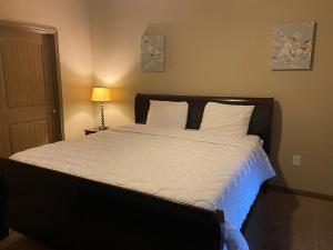 een bed met witte lakens en kussens in een slaapkamer bij Resort Style Apartment/Home - The Woodlands in The Woodlands