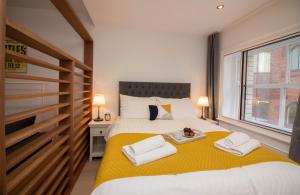 a bedroom with a large bed with towels on it at Beautiful City Centre Apartment in Liverpool
