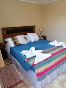a bedroom with a bed with towels on it at Hostal Illari in San Pedro de Atacama