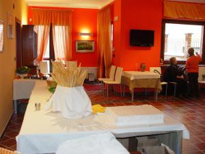 a room with red walls and people sitting at tables at B&B l'Angolo di Rosina con ristorante in Novello