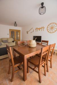 a dining room with a wooden table and chairs at Casa turística Me quedo en el pueblo in Muñana