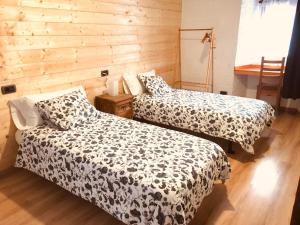 two beds in a room with wooden walls at Hospedaje Albizabal HVI00405 in Amurrio