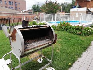 una tostadora sentada en el césped junto a una piscina en Cabañas San Gabriel Carlos Paz, en Villa Carlos Paz
