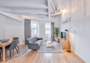 sala de estar con mesa, sillas y TV en Oporto Comfort Dom Hugo - Historic Apartments, en Oporto