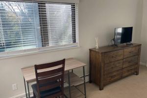 a room with a desk and a television and a wooden dresser at Very Spacious apartment close to Lions Head Gondola in Vail