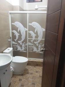 a bathroom with a shower with dolphins on the wall at CRUCITALIA suite x 4 in Crucita +8 photos