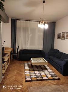 una sala de estar con un sofá y una mesa en Coronation Apartment, en Bratislava