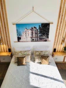 a bedroom with a bed and a painting on the wall at Apartamento T1 no centro TÊ-U in Torres Vedras