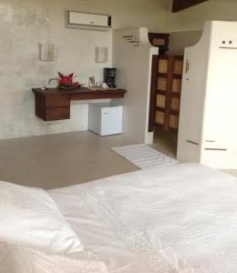a bedroom with a white bed and a counter at Casa Flor de Mar in Zipolite