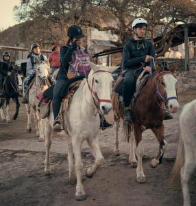 un grupo de gente montando caballos en un camino de tierra en Cabañas Las Perdices de Candonga en Agua de Oro