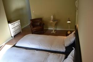 um quarto com uma cama, uma cadeira e uma cómoda em Villa des Roses Voltaire em Bruxelas