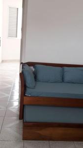 - un canapé avec des oreillers bleus installé sur un sol dans l'établissement Apto Pé na Areia, à São Vicente