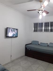 Cette chambre comprend un lit et une télévision murale. dans l'établissement Apto Pé na Areia, à São Vicente
