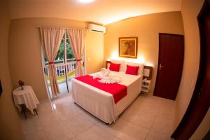 a bedroom with a bed with a red blanket at Pousada o Caribe de Maragogi in Maragogi +62 photos