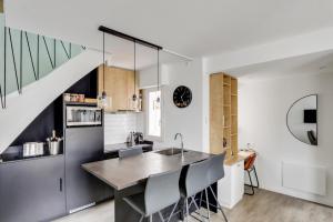 uma cozinha com um lavatório e um balcão com cadeiras em Sublime duplex Nantes Cathédrale em Nantes