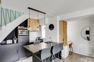 a kitchen with a sink and a counter with chairs at Sublime duplex Nantes Cathédrale in Nantes +29 photos