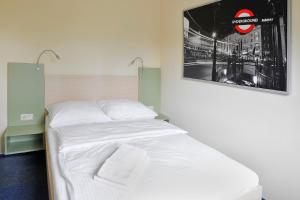 a bedroom with a white bed with a picture on the wall at Best Deal Airporthotel Weeze in Weeze