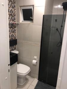 La petite salle de bains est pourvue d'une douche et de toilettes. dans l'établissement Apto Av Brasil 100 mts da praia, à Balneário Camboriú