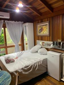 ein Schlafzimmer mit einem großen Bett in einer Küche in der Unterkunft Pousada e Hostel Vale do Rosa in Praia do Rosa