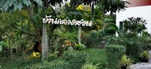 a sign in the middle of a garden at Baan Glangsuan Bang Kobua in Bang Chak