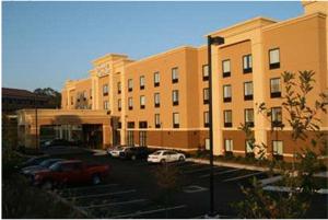 a large building with cars parked in a parking lot at Hampton Inn & Suites Laurel in Laurel