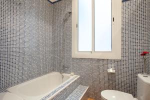 a bathroom with a tub and a toilet and a sink at Modernist Apartment Barcelona in Barcelona