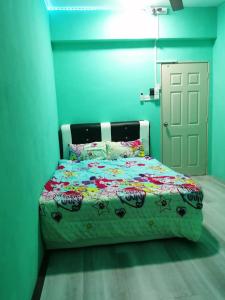 a bedroom with a bed with a colorful comforter at WORLD KIDS FANTASY in Lumut