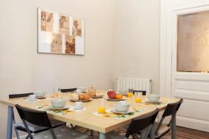 mesa de comedor con sillas y zumo de naranja en Modernist Apartment Barcelona, en Barcelona