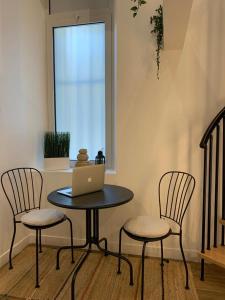 uma mesa com duas cadeiras e um portátil em Loft Luxe La Plaine em Marselha