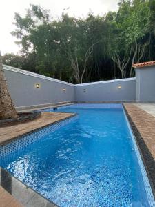 uma piscina com água azul num quintal em Marmeu Enseada com Hidro Aquecida Privativa no Guarujá