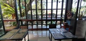two tables and chairs in front of a window at Sun smile(cafe & homestay) in Ubon Ratchathani
