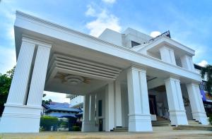 a white building with white columns and a sky at Hotel Blue Sky in Kurunegala