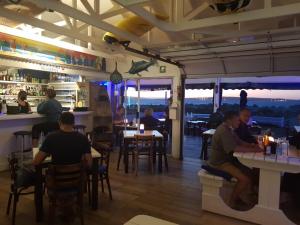 um grupo de pessoas sentadas em mesas em um restaurante em Friday Island em Langebaan