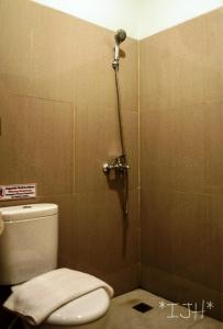 La salle de bains est pourvue d'une cabine de douche et de toilettes. dans l'établissement Mahakam24 Residence, à Jakarta