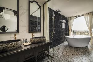 a bathroom with two sinks and a tub at Lalita Boutique Hotel & Spa Ninh Binh in Ninh Binh