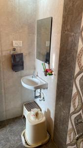 ein Bad mit einem Waschbecken und einem Spiegel in der Unterkunft Belle-Vue Holiday Homes in Panchgani