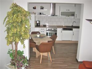 a kitchen and dining room with a table and a tree at Ferienwohnung Becker in Büren