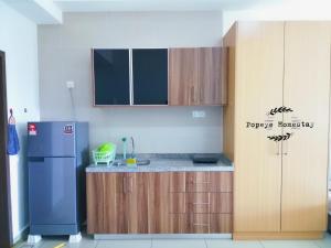 新山的住宿－Luxury Premium Suite @ Kempas Johor Bahru，厨房配有蓝色冰箱和木制橱柜。
