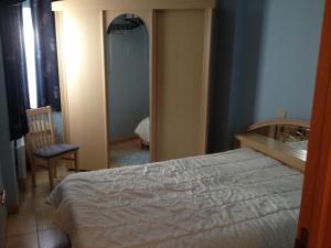 a bedroom with a bed and a mirror at centraal gelegen app met lateraal zeezicht in Ostend