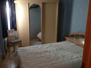 1 dormitorio con cama y espejo en centraal gelegen app met lateraal zeezicht, en Ostende