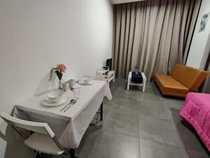 Ava Empire Damansara FRESH Room Everything Young في بيتالينغ جايا: غرفة معيشة مع طاولة بيضاء وأريكة