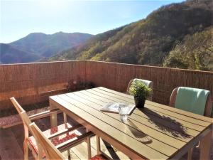 einen Holztisch auf einem Balkon mit Bergblick im Hintergrund in der Unterkunft Casa Benera in Maissana