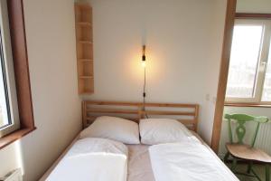 1 dormitorio pequeño con 1 cama con 2 almohadas en Amsterdam Farm Lodge en Ámsterdam