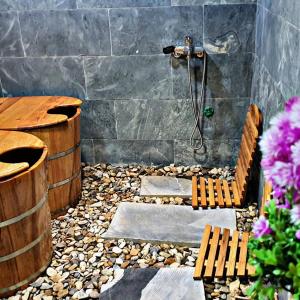 a bathroom with a shower with a bench and a tub at Meo Vac Clay House in Mèo Vạc