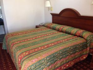 Bett in einem Hotelzimmer mit einer farbenfrohen Tagesdecke in der Unterkunft Executive Inn Robstown in Robstown