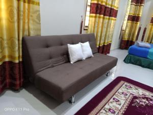 a brown couch with two pillows in a room at DBukit Losong Villa Kuala Terengganu in Kuala Terengganu