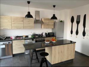 una cucina con armadi in legno e piano di lavoro nero di Appt Bouznika EDEN ISLAND pied sur Mer a Bouznika Altre 24 foto
