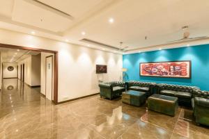 a living room with couches and a blue wall at Hotel The Balam in Jodhpur