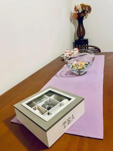 una caja en una mesa con un tazón de dulces en CASA DEI FIORI, en Somma Lombardo